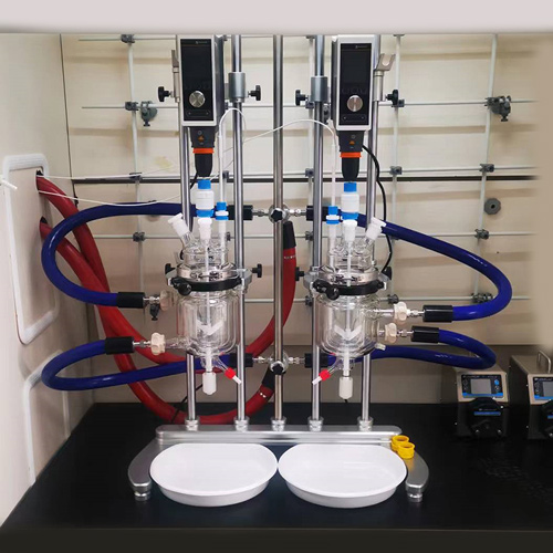 ReactoMate DATUM DUAL twin laboratory reactors situated in a fume cupboard, with all relevant tubing connected and overhead stirrers in place - Asynt, worldwide laboratory experts