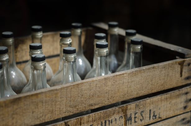 chemistry of rum production. Image shows old bottles in crates.